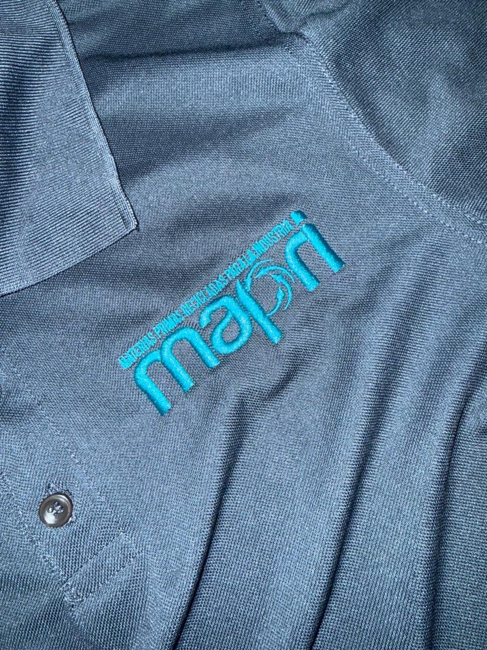 Closeup of gray Marin brand shirt with turquoise embroidered logo and button detail